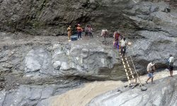 जोखिम मोलेर बाँसको भर्याङ्गबाट खाद्यान्न ओसारपसार (फोटो)