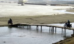 शुल्क तिरेर काठको पुल तर्दै स्थानीयवासी